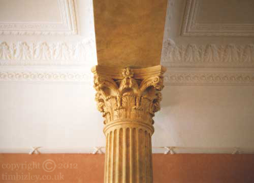 a corinthian column painted to look like stone with a paint effect